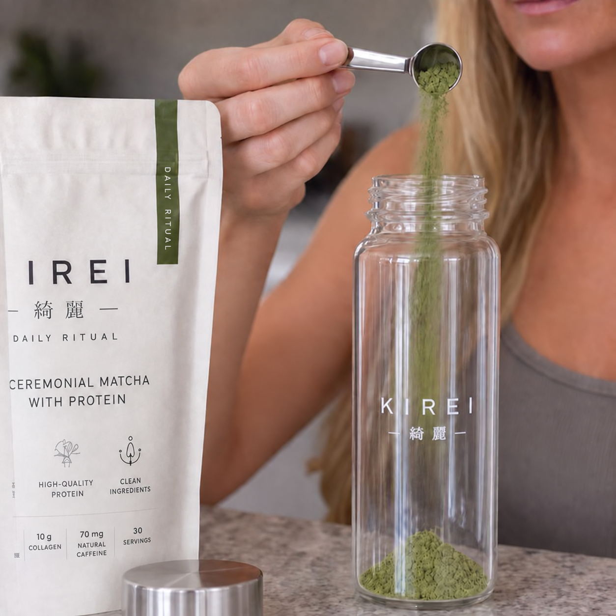 A scoop of KIREI matcha being added to the glass bottle