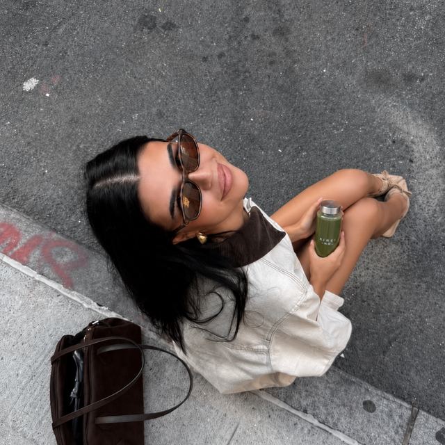 Woman sitting in the city holding a KIREI bottle